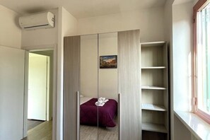 Relax in this serene bedroom with a comfortable bed, framed artwork, and ample storage in the wardrobe.