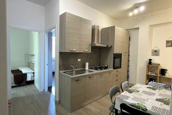 Enjoy a meal for two in this kitchen with dining area, featuring a table and a bathroom with shower and toilet nearby.