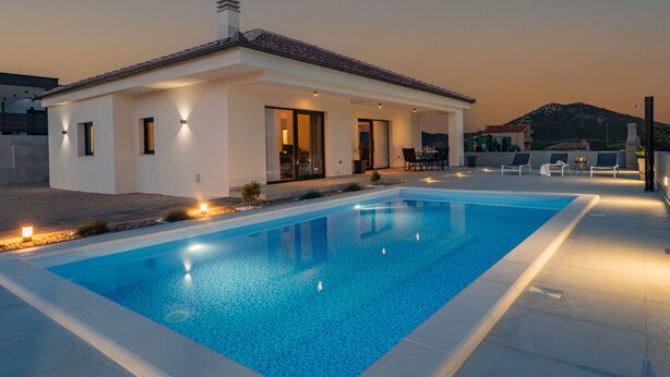 A modern house with a swimming pool, a patio with outdoor furniture, and a mountain in the background. - Villa Miki Zadarvillas (Polaca)