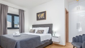 A modern bedroom with a large bed, a nightstand, a chair, and a wardrobe. - Villa Miki Zadarvillas (Polaca)