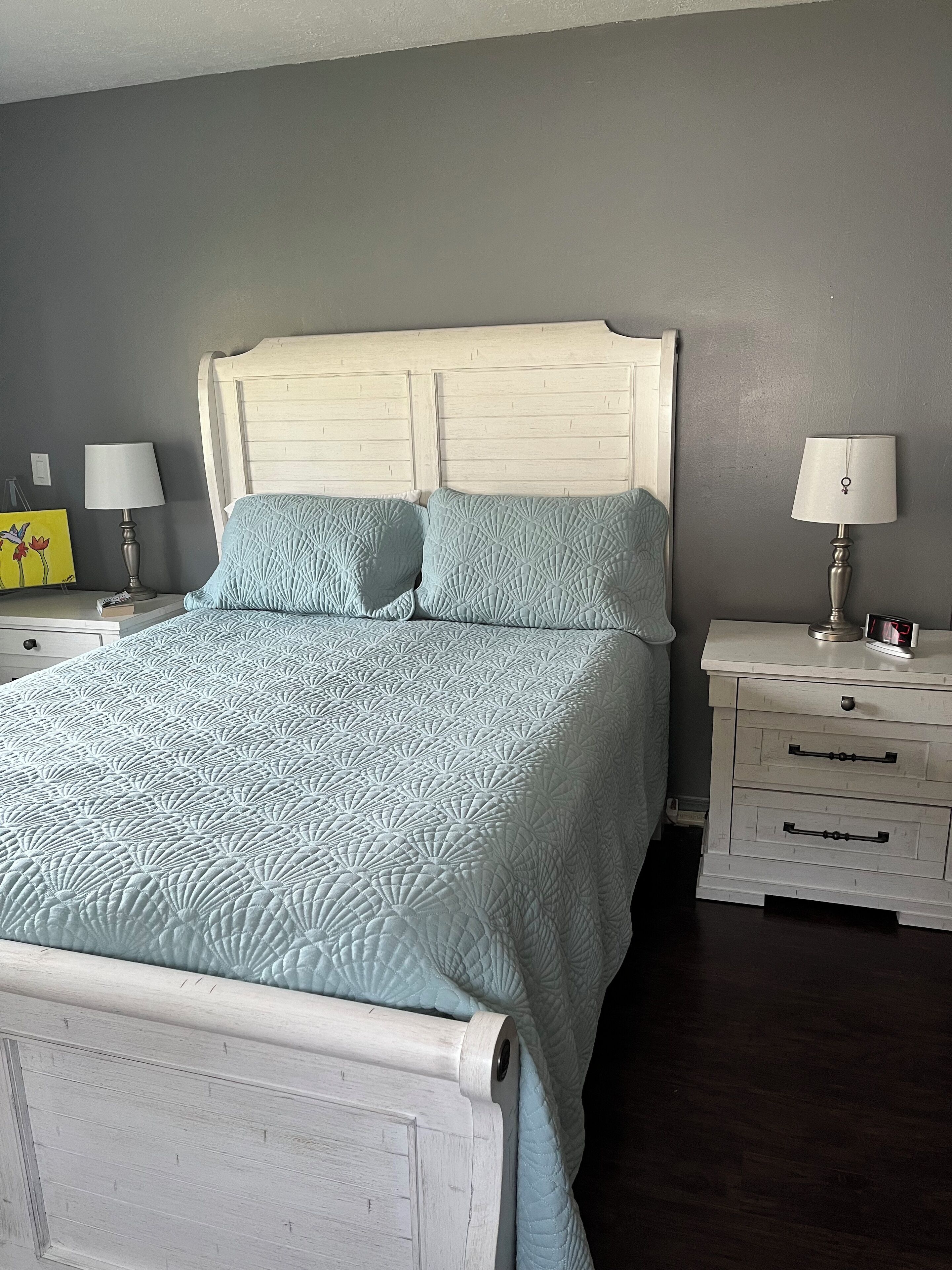 Een slaapkamer met een bed, twee nachtkastjes en een bedbank.