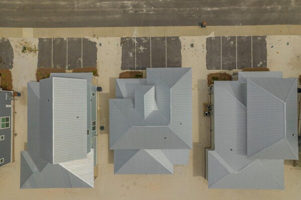 An aerial view of a parking lot with three buildings.