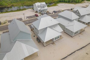 A coastal property with multiple buildings, a parking area, and a body of water in the background.