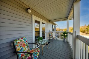 Relax on the covered porch with a glass-top table and two comfortable chairs, surrounded by lush views.