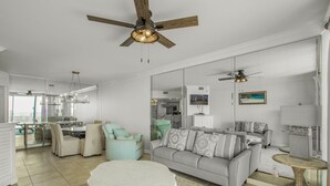 A spacious living room with a grey sofa, a round coffee table, and a ceiling fan. - Summer House 103a (Orange Beach)