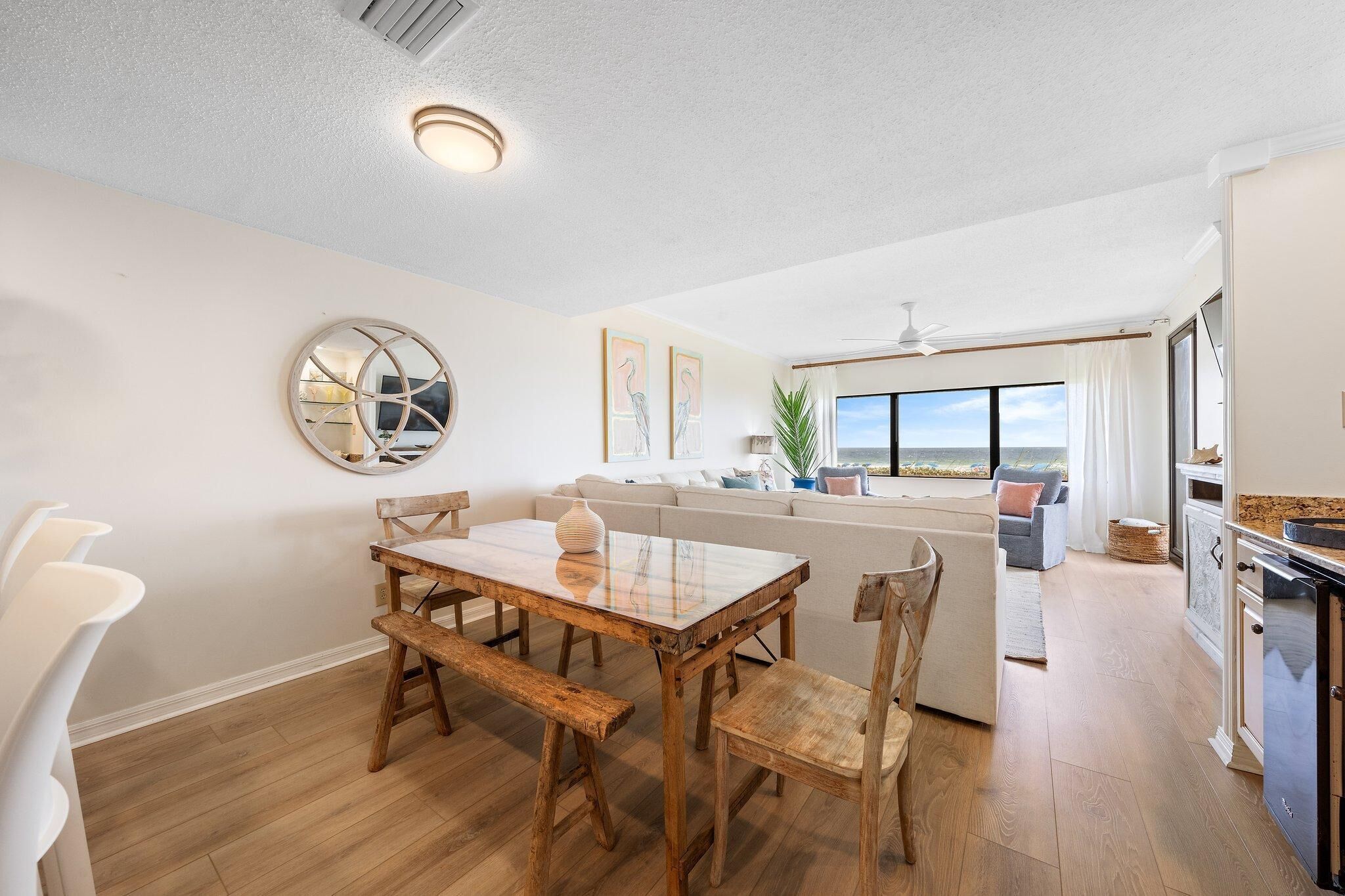 A modern kitchen with a dining area, a large window, and a view of the outdoors.