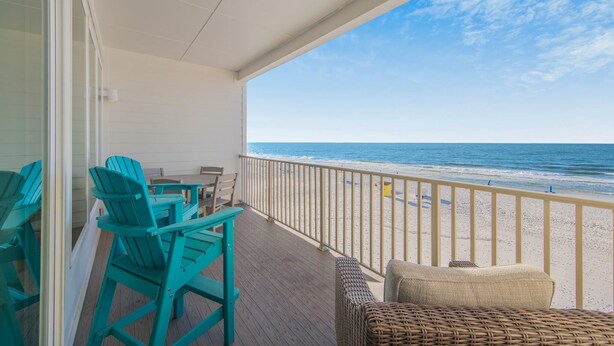 A balcony with a view of the beach, turquoise chairs, and a wicker sofa. - Sea Glass 304 (Gulf Shores)