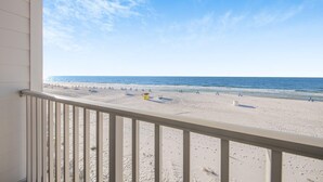 A beach view from a balcony with a railing, sandy beach, and ocean. - Sea Glass 304 (Gulf Shores)