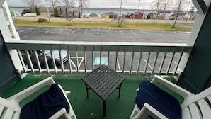 A balcony with a view of a parking lot and houses across a body of water. - Webb's Year Round Resort (Mayville)