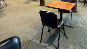 A hotel lobby with a reception desk, seating area, and a kitchenette in the background. - Webb's Year Round Resort (Mayville)