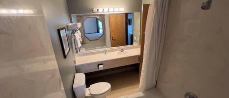 A modern bathroom with a bathtub, toilet, and sink.