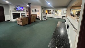 A spacious living room with a fireplace, a television, and a coffee table. - Webb's Year Round Resort (Mayville)