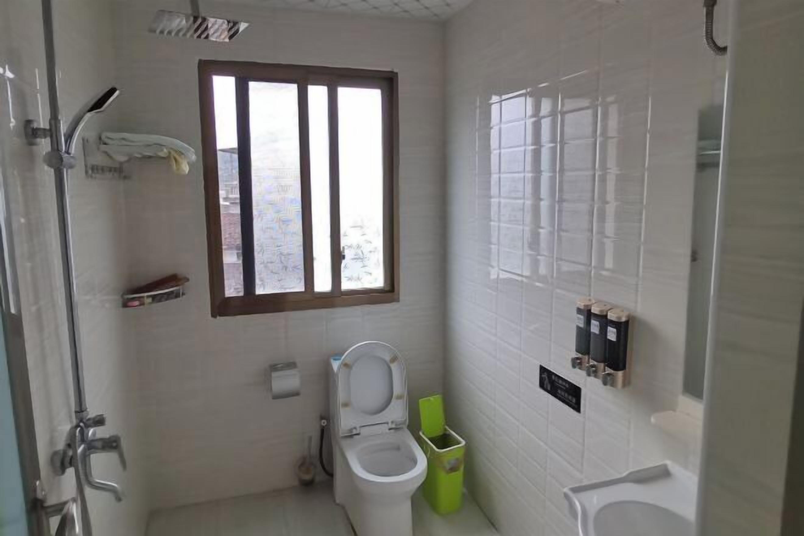 A small, modern bathroom with a toilet, bidet, and shower.