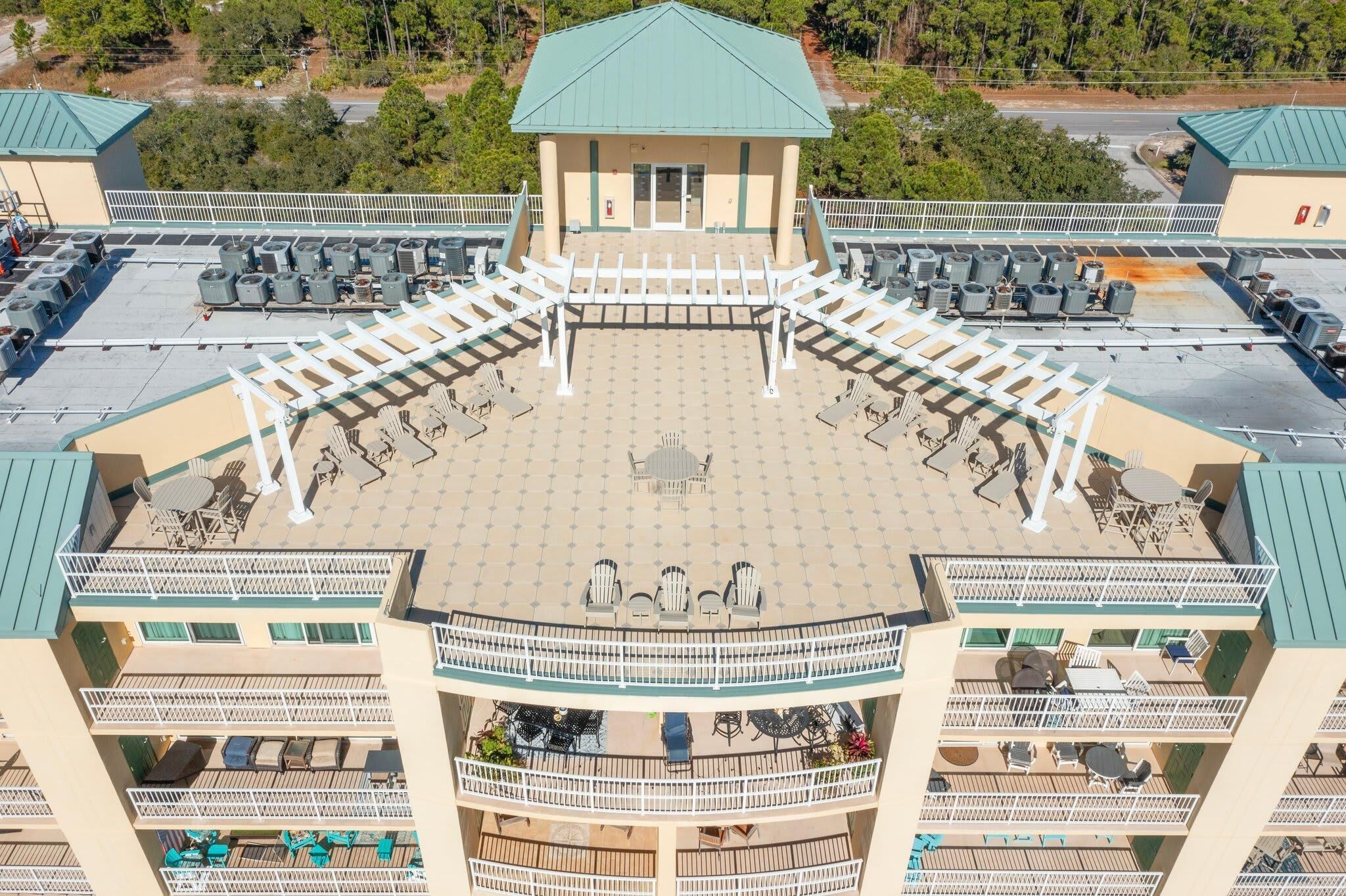 A multi-story hotel with outdoor seating areas, a central courtyard, and balconies.