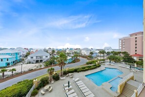 A resort with a swimming pool, lounge chairs, and a view of the surrounding buildings. - The Indies 303 (Gulf Shores)