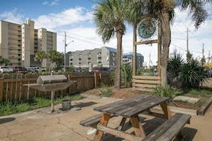 Enjoy an outdoor space with a picnic table and barbecue grill, surrounded by lush greenery.