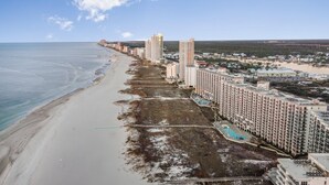 A coastal hotel with multiple high-rise buildings, a beach, and a swimming pool. - Phoenix Viii 81201 (Orange Beach)