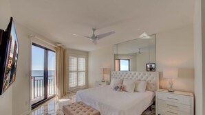 A spacious bedroom with a large bed, a sitting area, and a balcony with a view. - Seachase 803w (Orange Beach)