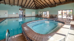 An indoor swimming pool with a wooden ceiling, a hot tub, and lounge chairs. - Seachase 803w (Orange Beach)
