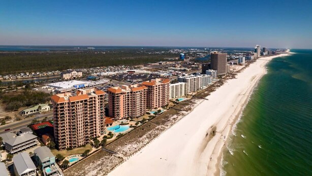 A coastal hotel with multiple high-rise buildings, a beach, and a clear view of the ocean. - Seachase 803w (Orange Beach)