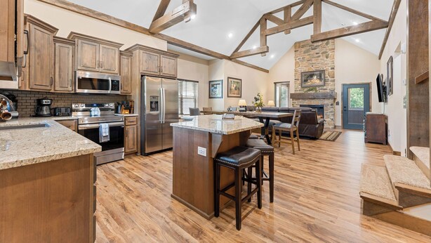 A spacious kitchen with wooden beams, a large island, and modern appliances.
