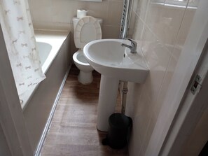 A bathroom with a toilet, sink, and bathtub. - Lovely 1- Double Bed Studio in London (London)