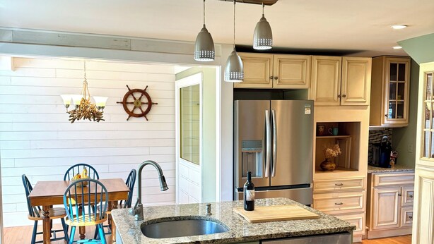 A modern kitchen with a central island, stainless steel appliances, and light-colored cabinetry. - Ocean view, private 4 Bedroom home just steps to the beach! (Old Orchard Beach)
