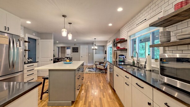 A modern kitchen with a central island, stainless steel appliances, and a view of the outdoors. - Cozy 3BR Getaway, Lake access, Fire Pit, Trails (Mount Airy)