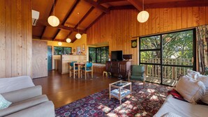 Un espacio habitable amplio con paredes de madera, un ventanal grande y una zona de estar acogedora.