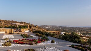 A rooftop garden with a pergola, various plants, and a view of the countryside. - Modern Cycladic House (Naxos)