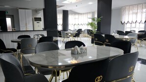 A modern dining area with round tables and black chairs with gold accents. - ETAP BULVAR HOTEL (Ankara)