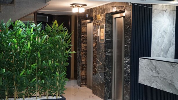 A modern elevator area with marble walls and a reception desk. - ETAP BULVAR HOTEL (Ankara)