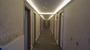 A hotel hallway with carpeted floors, doors on both sides, and recessed lighting. - ETAP BULVAR HOTEL (Ankara)