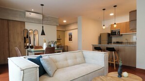 Una sala de estar moderna con un sofá, comedor y cocina.