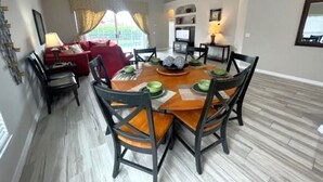 Un coin repas avec une table ronde, des chaises et un ventilateur de plafond.