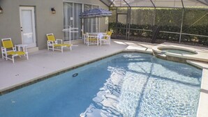 Une piscine avec des chaises longues et un espace patio couvert.