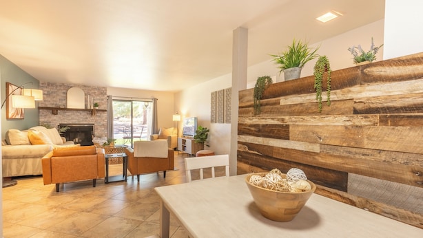 A modern living room with a fireplace, comfortable seating, and a wooden accent wall. - 3 Bedrooms, Sleeps 7, Pool/Spa, Tennis/Pickleball, Red Rock Views, Restaurants  (Sedona)