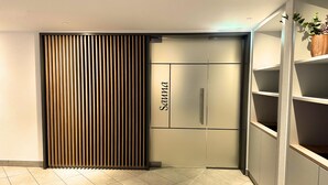 Un interior moderno con una puerta corredera que indica “SOMMA”, suelo de baldosas y estanterías empotradas.