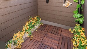 A small, enclosed space with a wooden floor, a metal ladder, and a wall-mounted shelf.