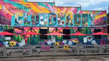Un mural colorido con la palabra "GLOUCESTER" y diversas imágenes de personas y naturaleza.