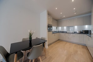 Enjoy cooking in this well-equipped kitchen with a dining area and potted plant.