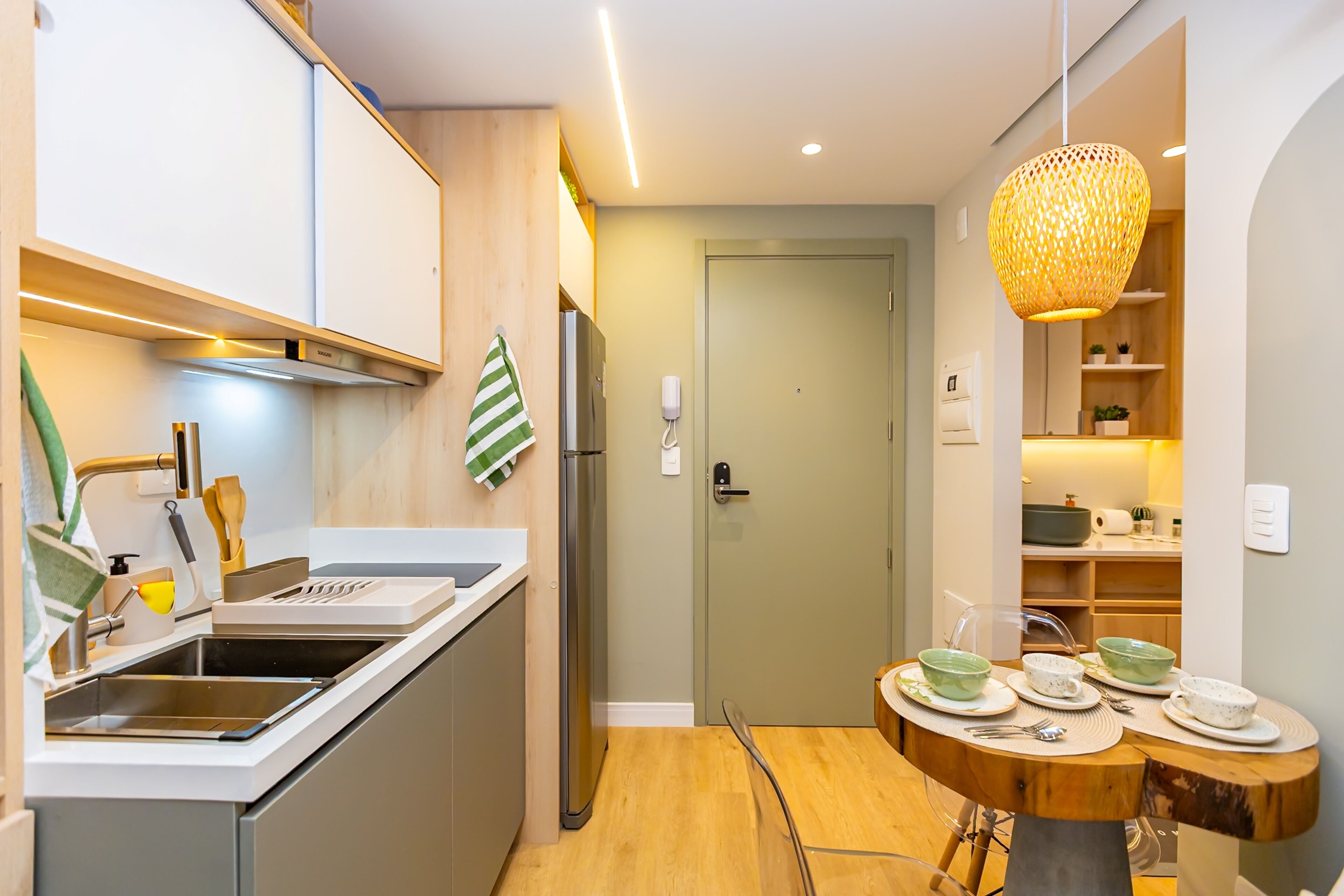 Une cuisine moderne équipée d’un évier, d’une cuisinière et d’un coin repas avec une table ronde et des chaises.
