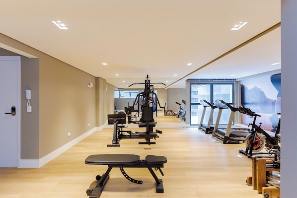 A gym with exercise equipment, treadmills, and a bench. - Edifício Lins 236 (Curitiba)