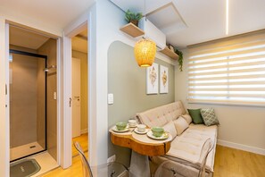 A compact bedroom with a bed, bedside table, and a hanging light fixture.