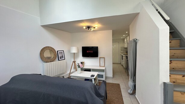Ein modernes Schlafzimmer mit einem Bett, einem Schreibtisch, einem Fernseher und einer Treppe.