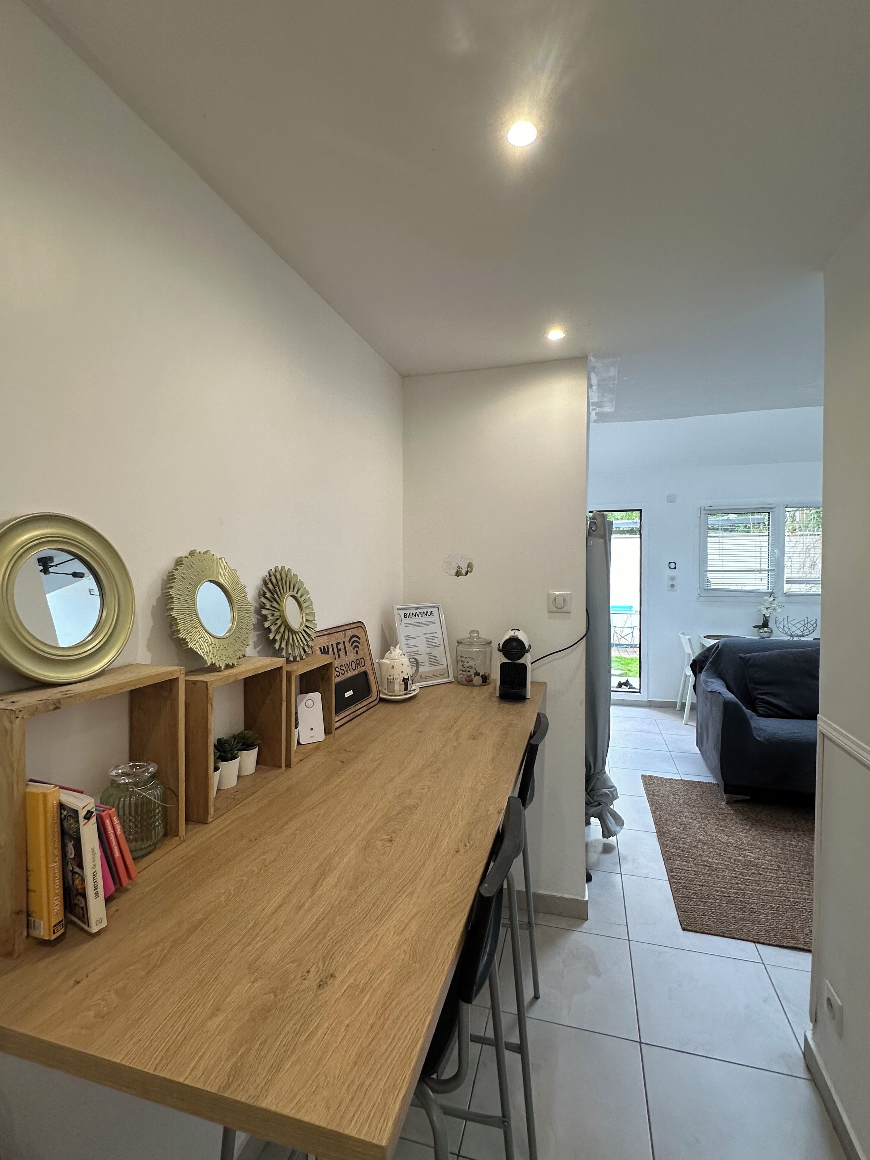 Una cocina moderna con una mesa de madera, estantes empotrados y vistas al comedor.