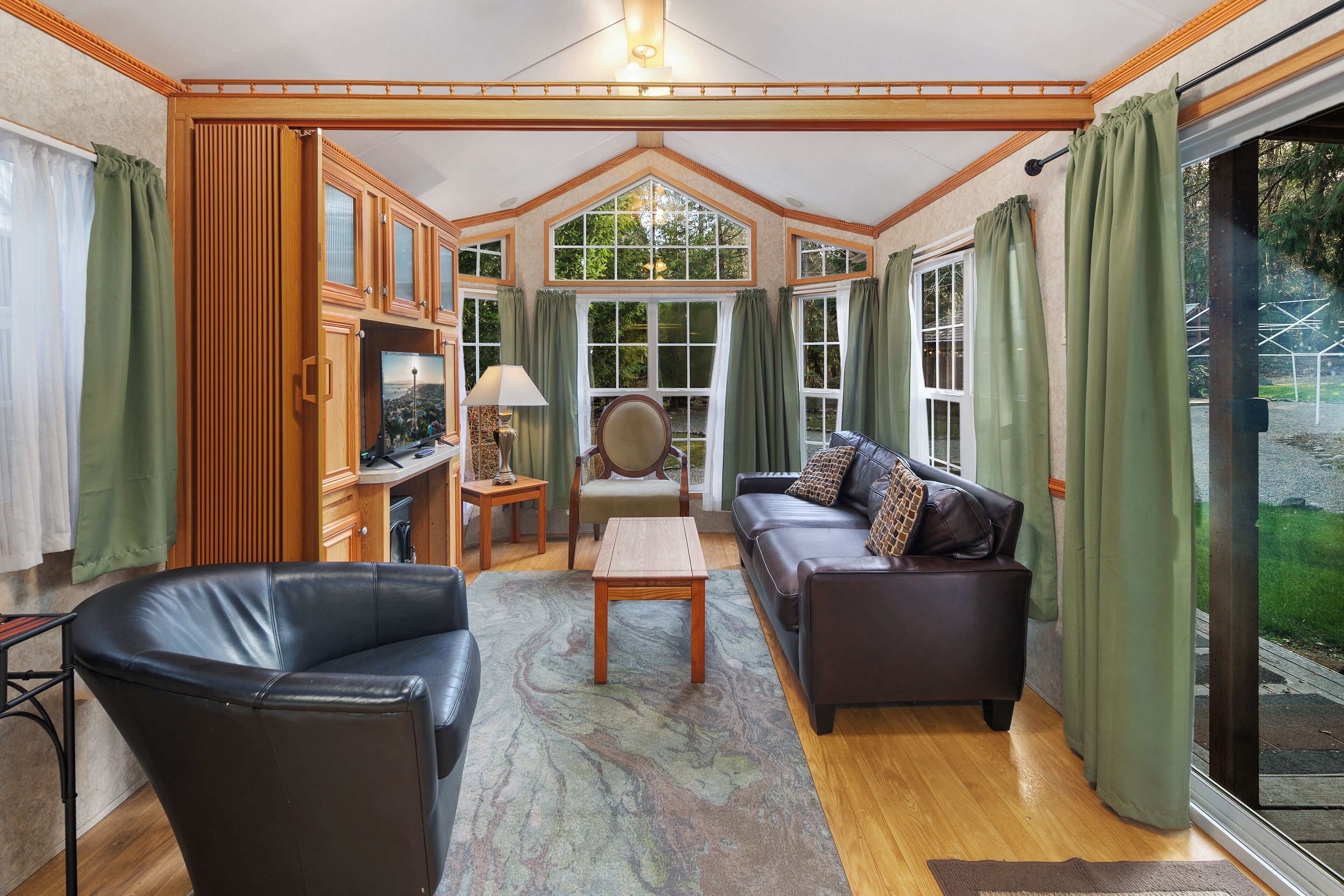 A cozy living room with a fireplace, leather sofa, and a wooden coffee table.