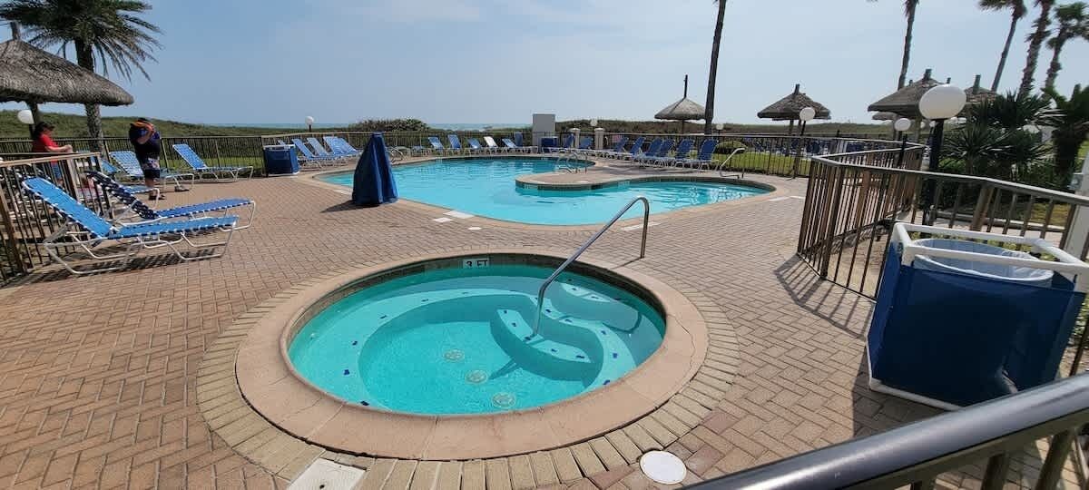 Un área de piscina con sillas de descanso y un jacuzzi.