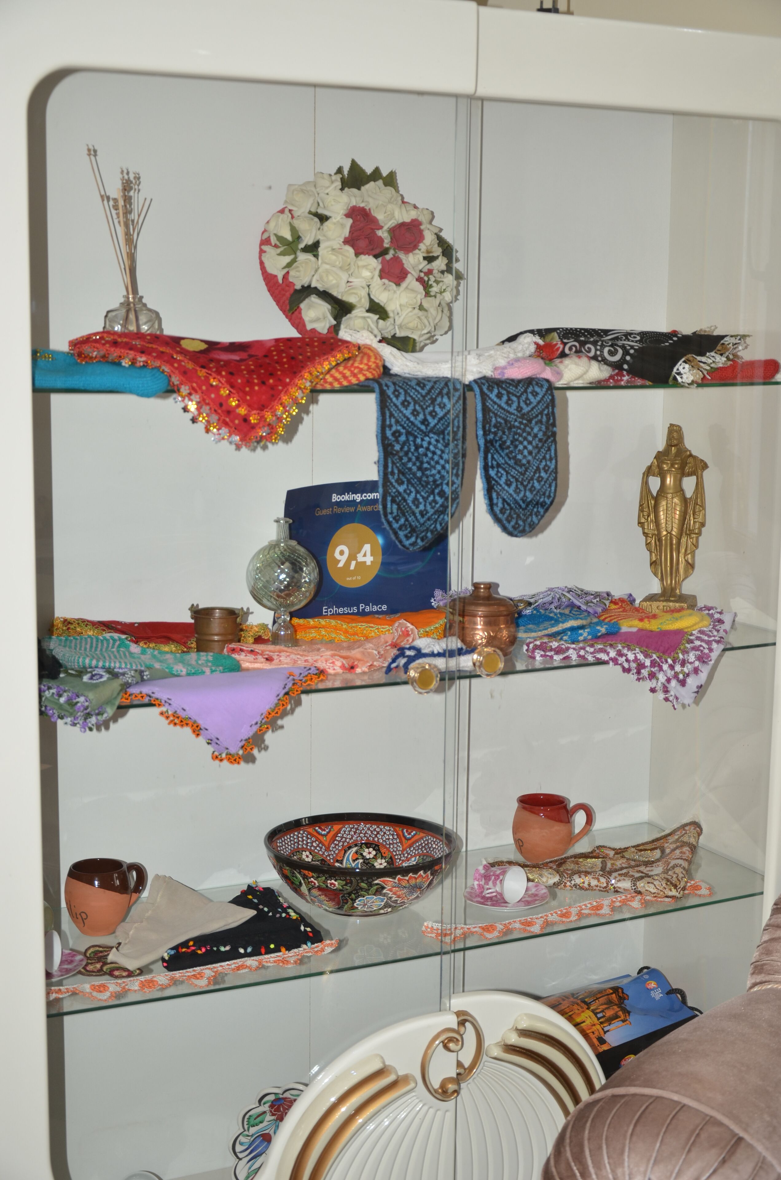 A display of cultural artifacts including textiles, pottery, and a decorative vase.