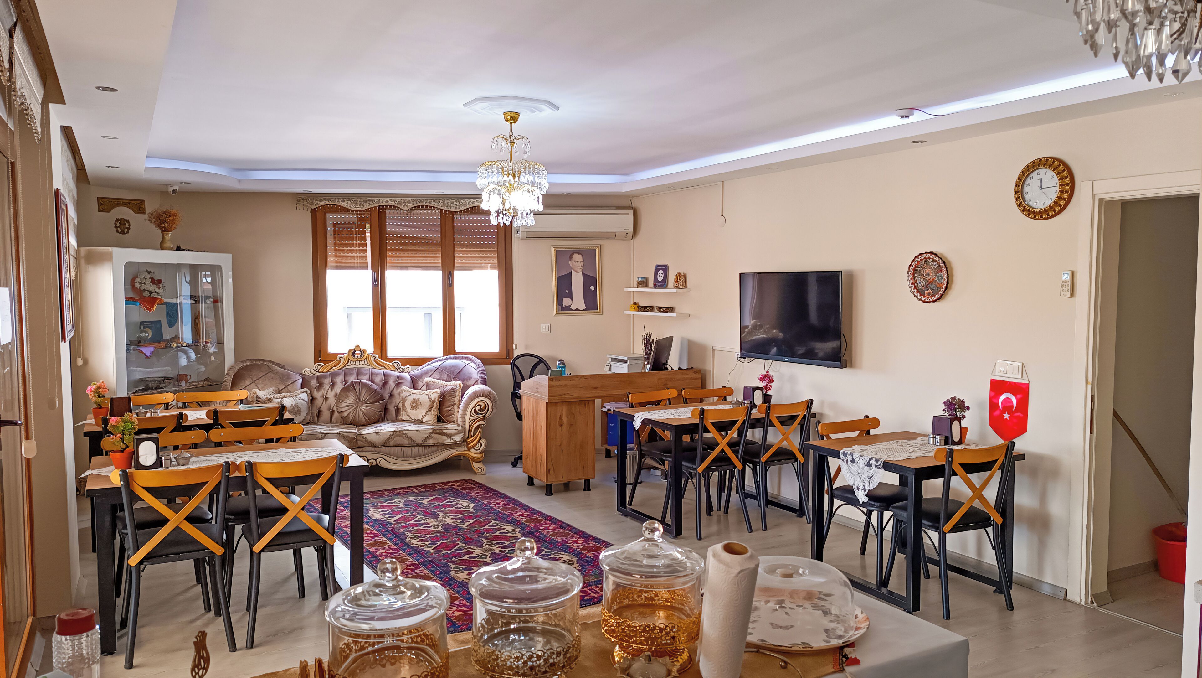 Un salón amplio con sofá, mesa de comedor, sillas y televisor.